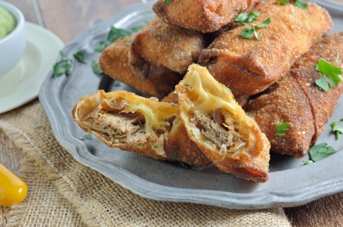Pull Pork and Smoked Gouda Egg Rolls Recipe - Succulent, sweet and zesty pulled pork wrapped in a crispy egg roll with silky smoked gouda cheese and served alongside Avocado Green Goddess Dressing.
