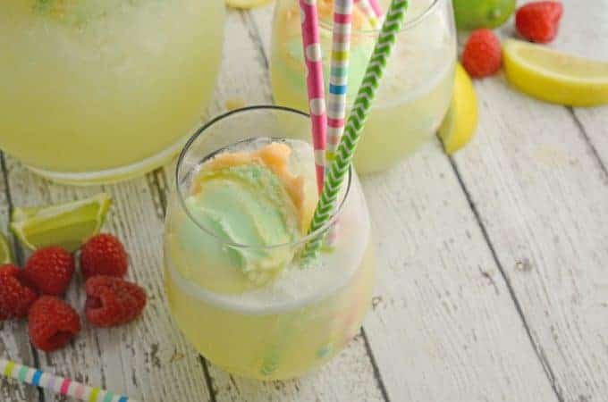 Frozen Limeade Sherbet Floats- a refreshing summer drink perfect for parties and BBQs! Cool limeade blended with ice and topped with a heaping scoop of rainbow sherbet! Perfect for kids, but an adult option available. www.savoryexperiments.com