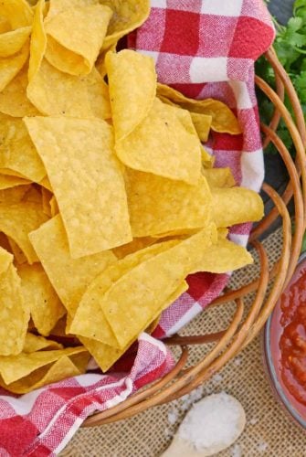 Homemade Tortilla Chips in a basket with salsa and cilantro