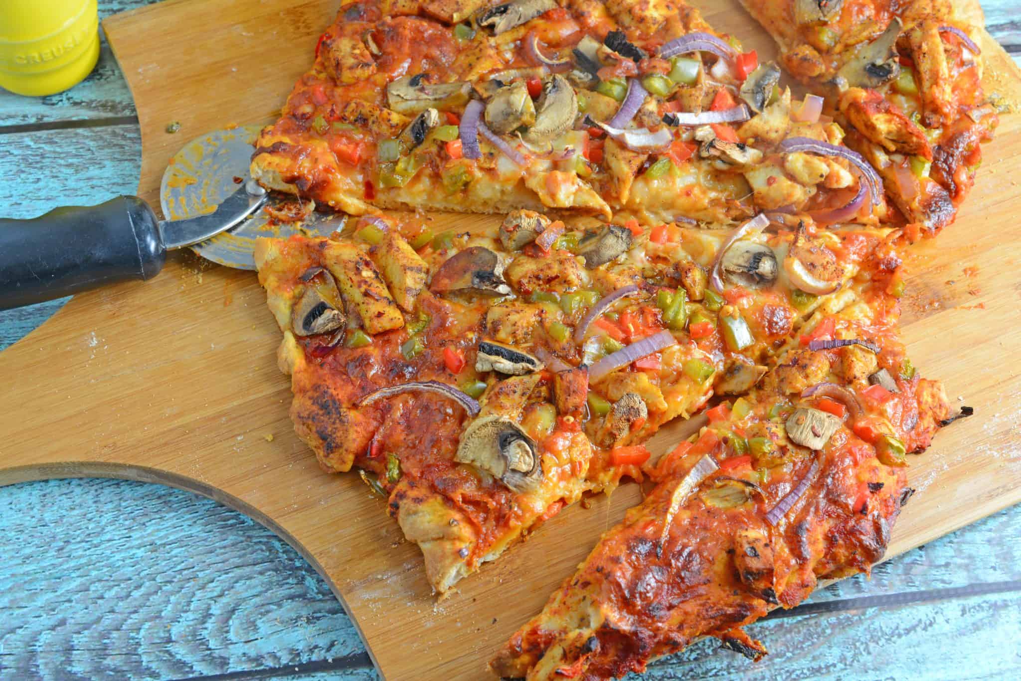 Caribbean Jerk Chicken Pizza is an easy homemade pizza recipe using spicy chicken, fresh vegetables and a touch of honey. #homemadepizza #jerkchicken #jerkchickenpizza www.savoryexperiments.com 