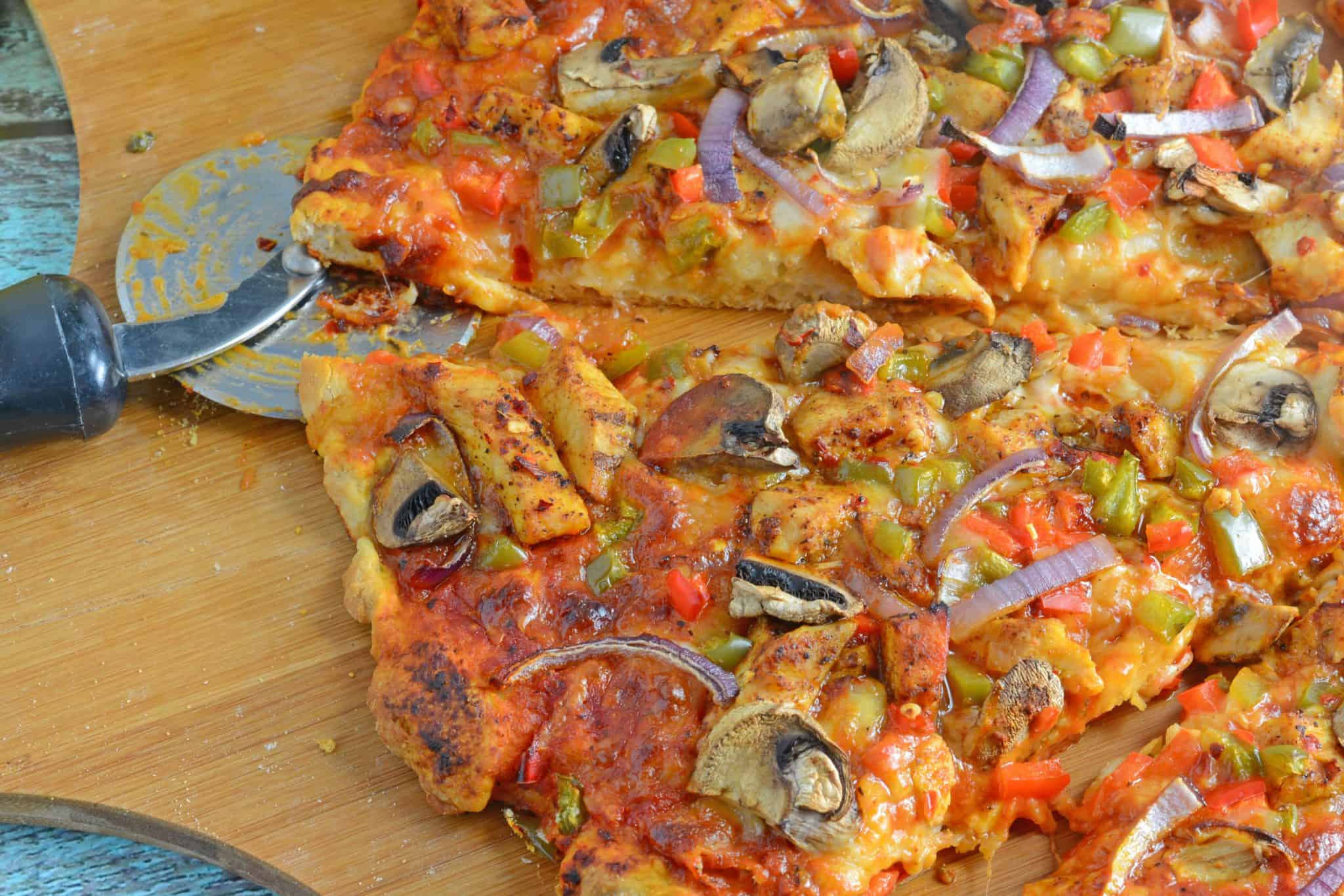 Caribbean Jerk Chicken Pizza is an easy homemade pizza recipe using spicy chicken, fresh vegetables and a touch of honey. #homemadepizza #jerkchicken #jerkchickenpizza www.savoryexperiments.com