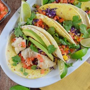 Easy fish taco recipe full of flavor with pico de gallo, shredded cabbage, avocado, queso fresco and a special homemade hot sauce. #fishtacorecipe #bestfishtacos www.savoryexperiments.com