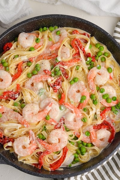 overhead of shrimp alfredo in a large skillet