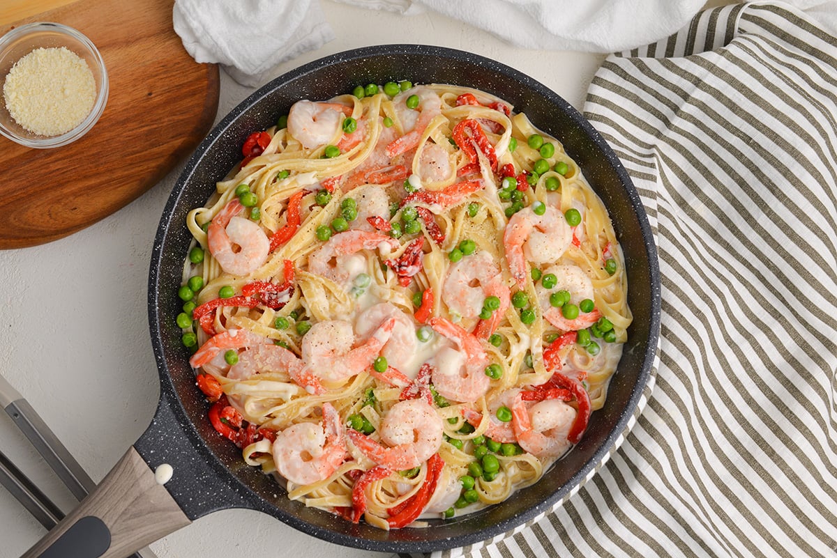 overhead of shrimp alfredo in a large skillet