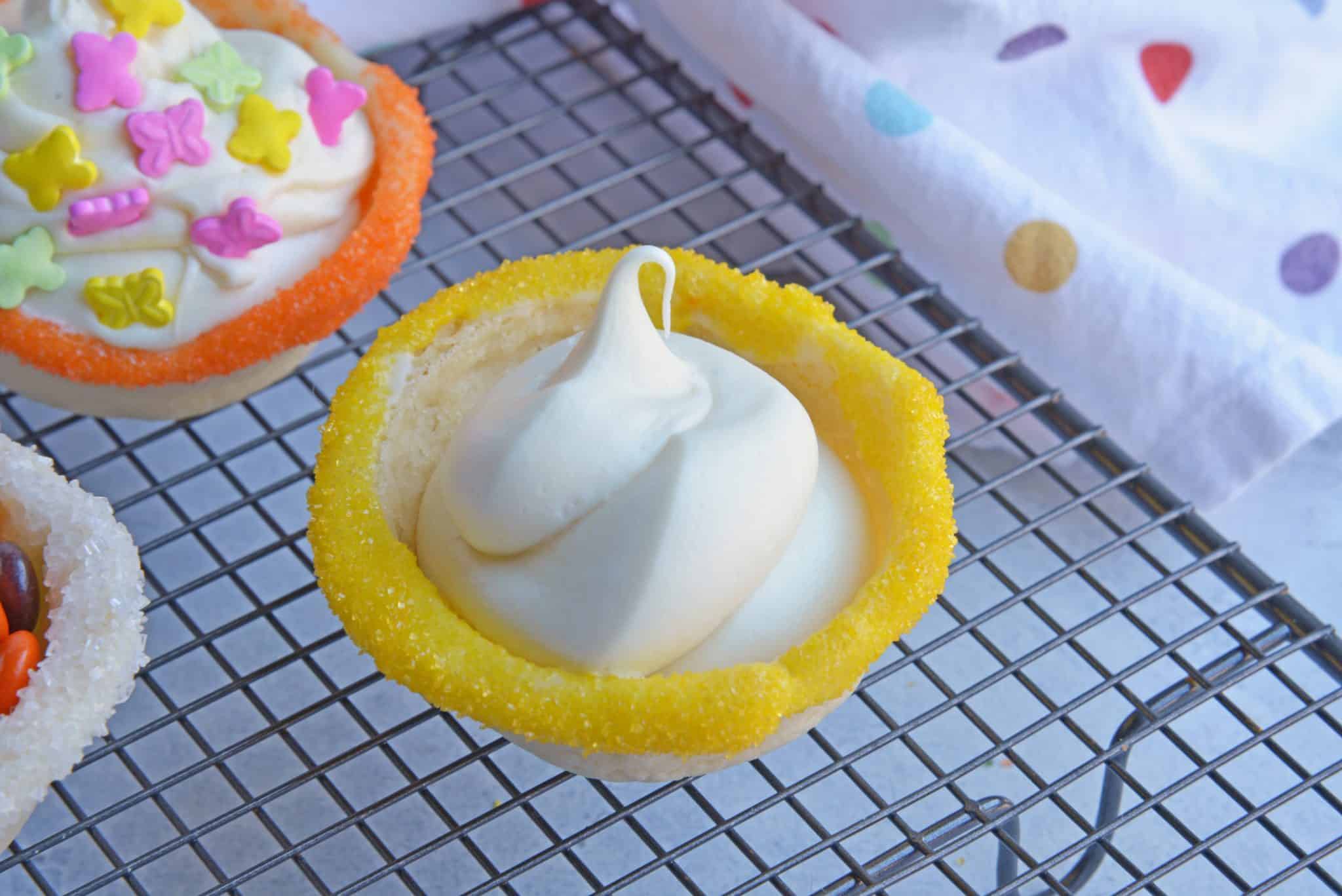 This Sugar Cookie Cups recipe puts a spin on your typical ice cream cone. Why choose between cookies or ice cream when you can have both! #sugarcookiecups #howtomakesugarcookiecups www.savoryexperiments.com