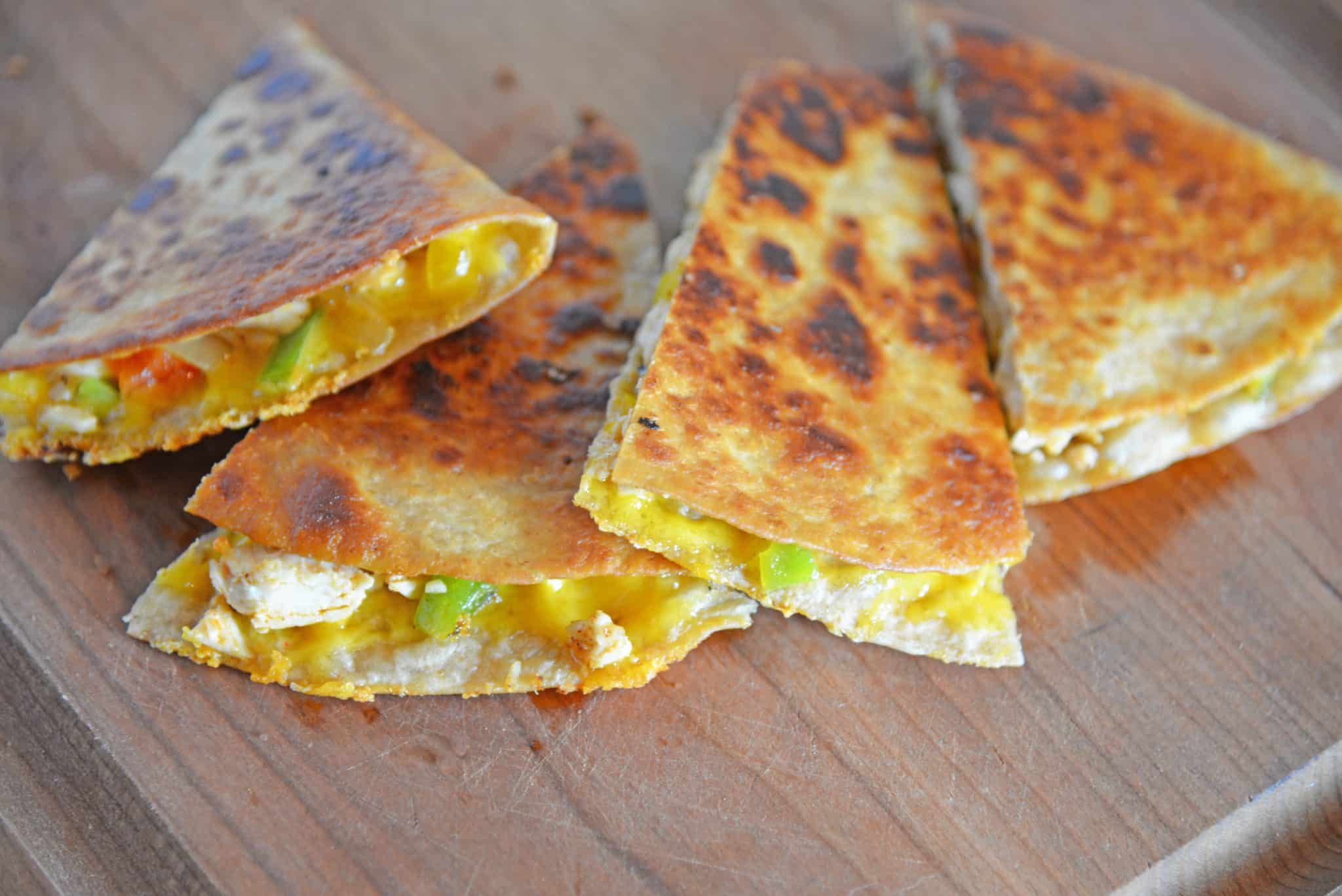 This Chicken Quesadillas Recipe is made with crispy tortillas, chopped vegetables and lots of cheese! This shows you how to make quesadillas the easy way! #chickenquesadillarecipe #howtomakechickenquesadillas www.savoryexperiments.com