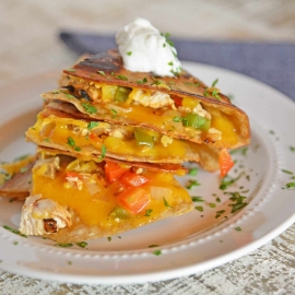 pile of chicken quesadillas with sour cream