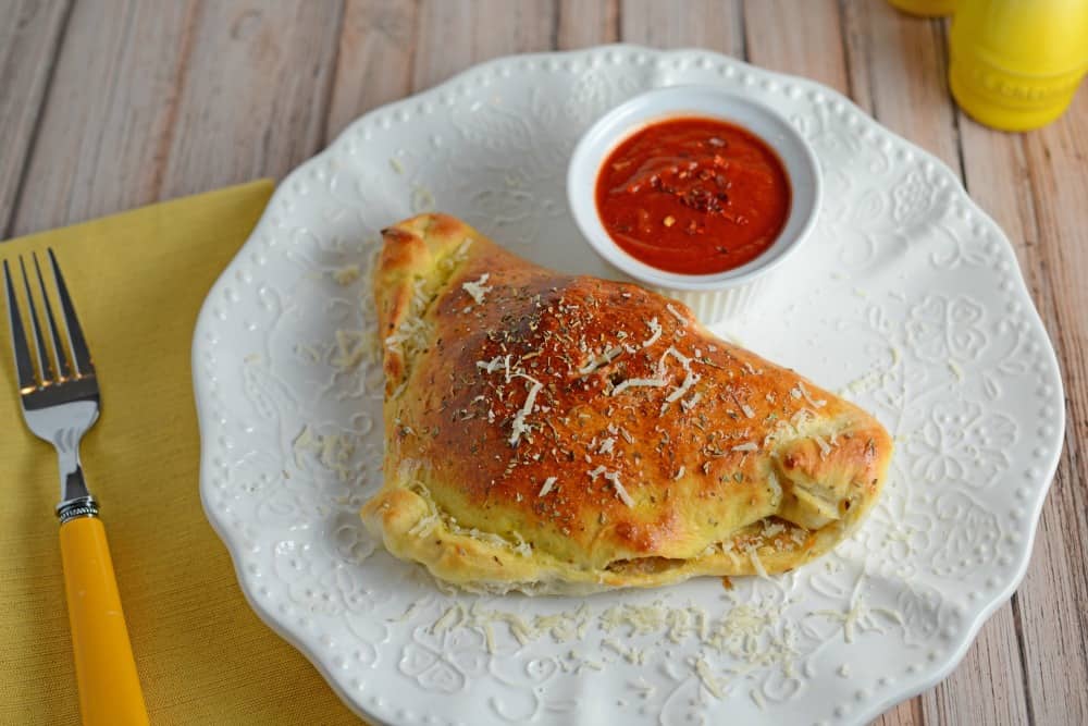 This Easy Calzones Recipe is made with just a handful of ingredients! This homemade calzones recipe is perfect for a “make your own calzone bar” for any party! #calzonerecipe #howtomakeacalzone #homemadecalzonerecipe www.savoryexperiments.com