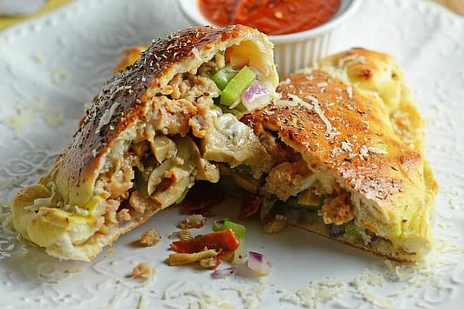 This Easy Calzones Recipe is made with just a handful of ingredients! This homemade calzones recipe is perfect for a “make your own calzone bar” for any party! #calzonerecipe #howtomakeacalzone #homemadecalzonerecipe www.savoryexperiments.com