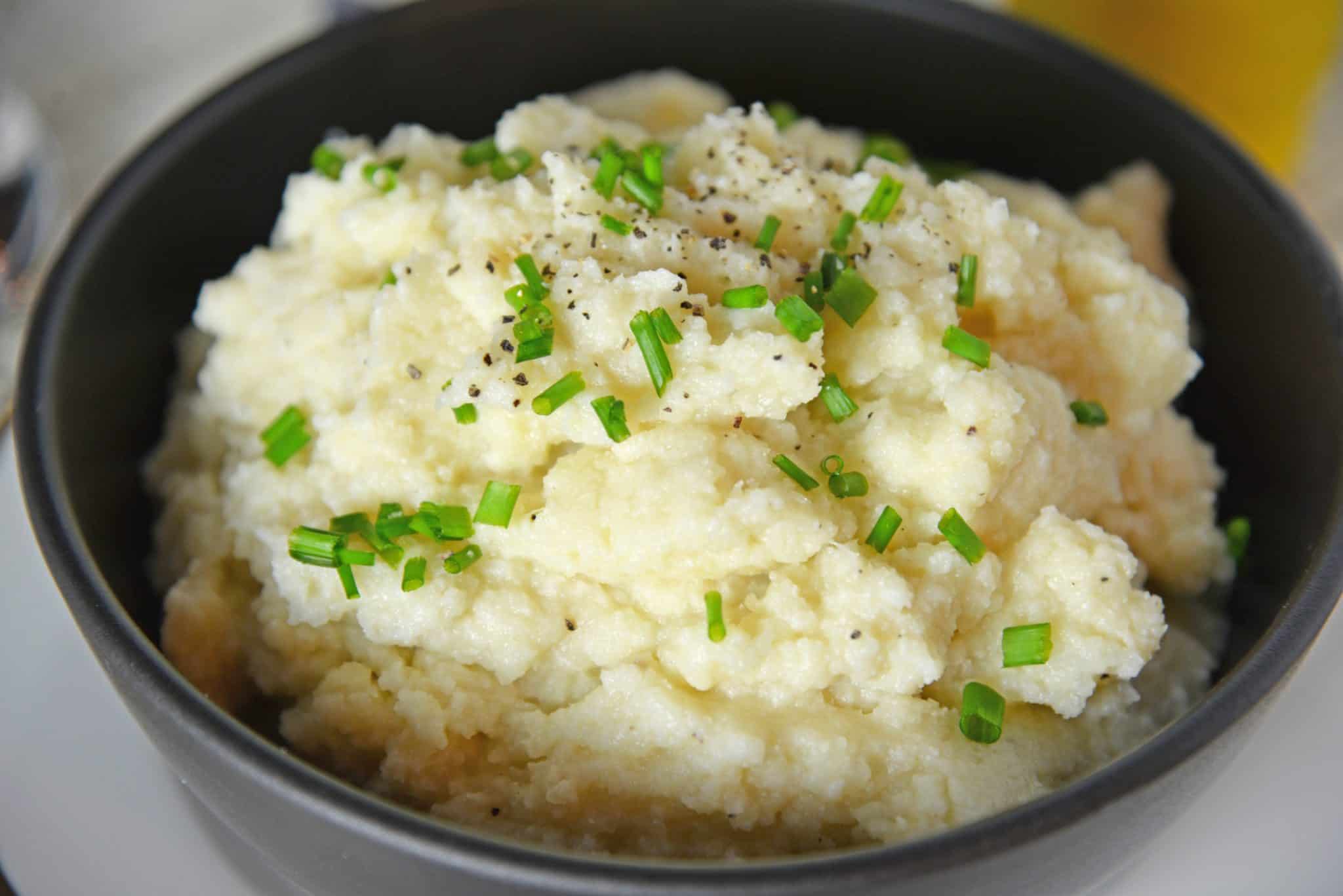 Mashed Cauliflower is a healthier alternative to mashed potatoes, with fewer carbs! This Mashed Cauliflower recipe is perfectly smooth and creamy! #mashedcauliflower #cauliflowermashedpotatoes www.savoryexperiments.com