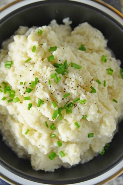 Mashed Cauliflower is a healthier alternative to mashed potatoes, with fewer carbs! This Mashed Cauliflower recipe is perfectly smooth and creamy! #mashedcauliflower #cauliflowermashedpotatoes www.savoryexperiments.com