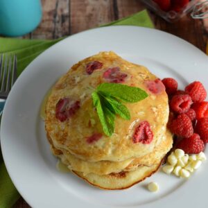 White Chocolate and Raspberry Pancakes Recipe - The perfect fluffy buttermilk pancakes dotted with fresh raspberries, white chocolate chips and homemade Dutch honey syrup. www.savoryexperiments.com
