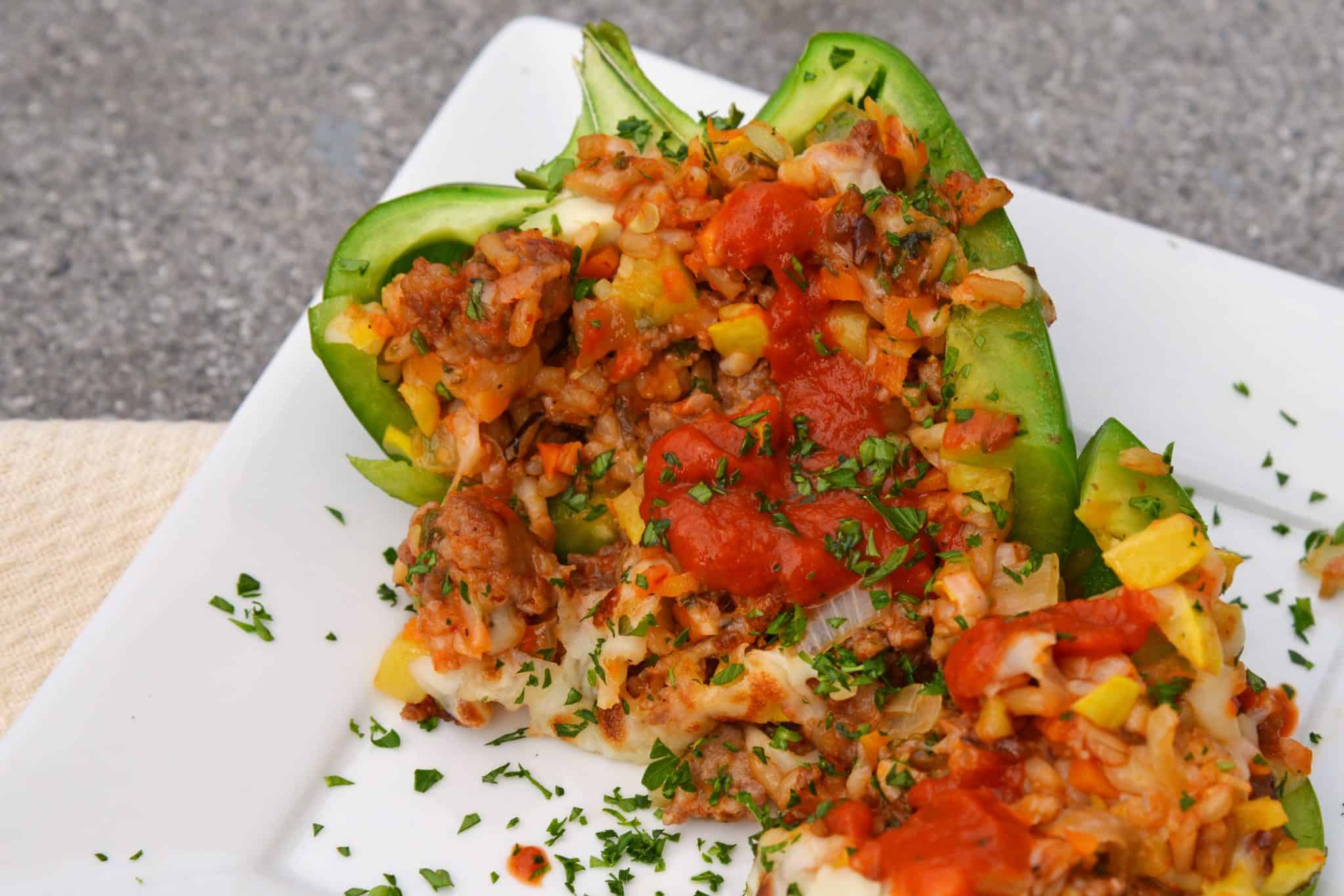 Sausage Stuffed Bell Peppers are a classic Italian dish using stuffed peppers with rice, sausage and lots of colorful vegetables. This make ahead dinner recipe will be a family favorite. #makeaheaddinner #stuffedbellepeppers www.savoryexperiments.com