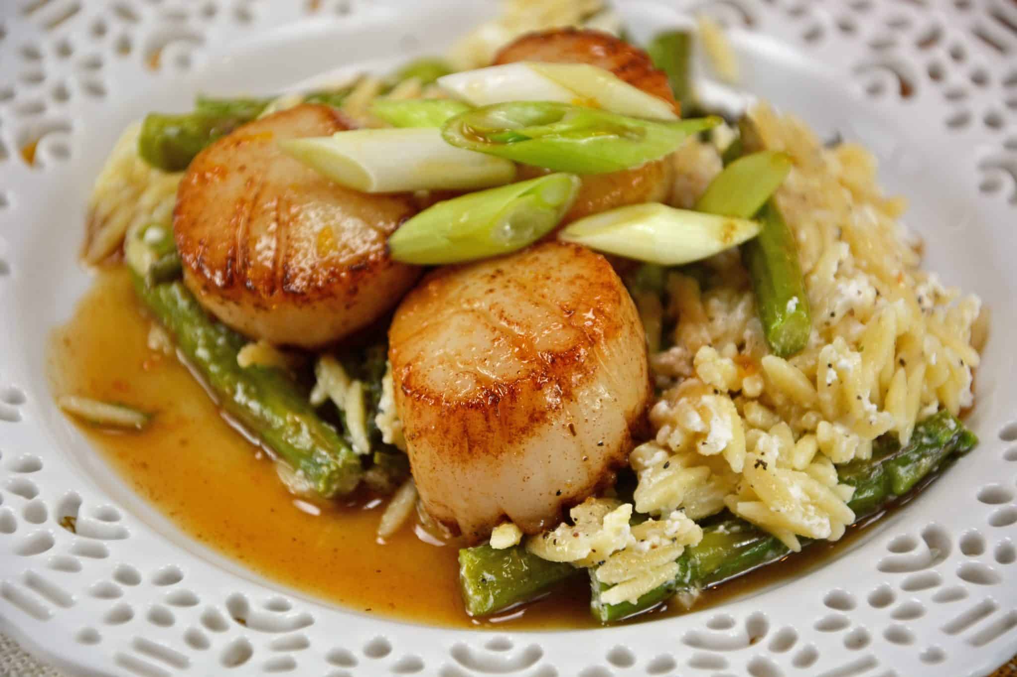 Orange Caramel Scallops are an easy recipe that brings the feel of the restaurant right to your home! Scallops covered in a sticky, sweet orange caramel sauce! #scallopsrecipe #seascallopsversusbayscallops www.savoryexperiments.com