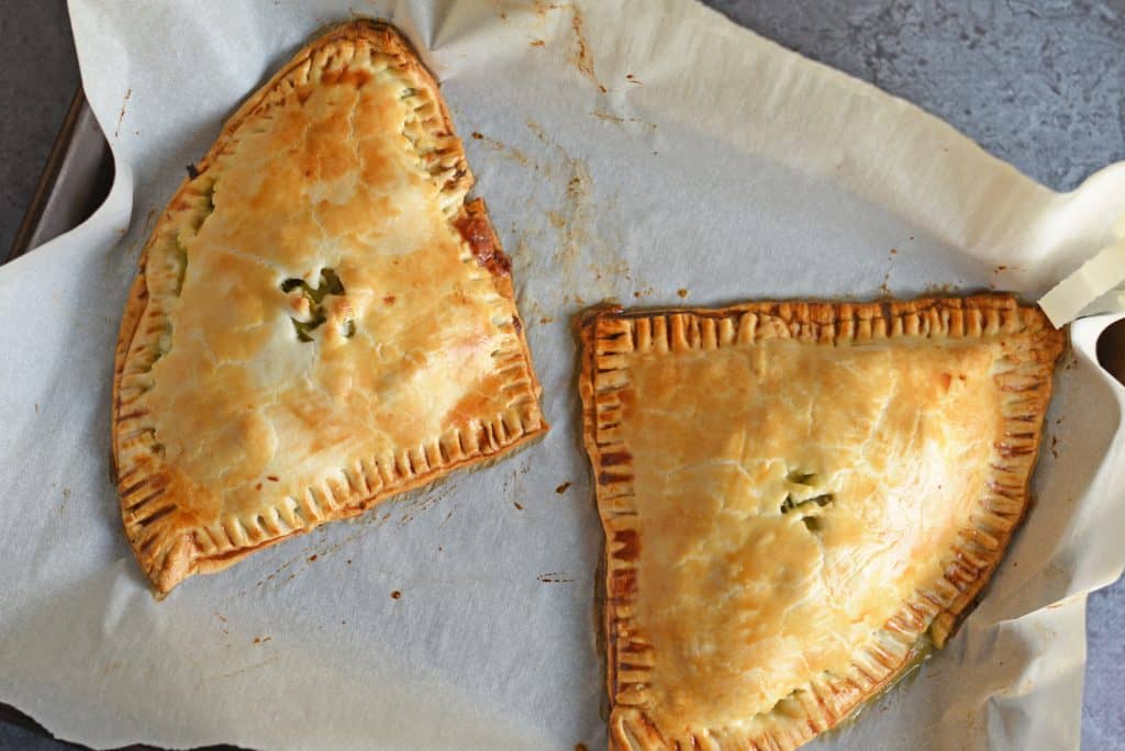 Artichoke Chicken Pot Pie is an easy hand pie recipe stuffed with shredded chicken, artichokes, spinach, red onion, cheese and zesty Italian dressing. #chickenpotpie #handpies www.savoryexperiments.com