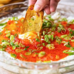 dipping a crostini in goat cheese dip