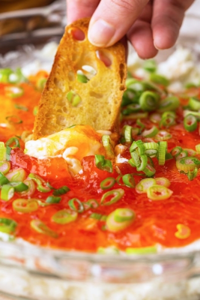 dipping a crostini in goat cheese dip