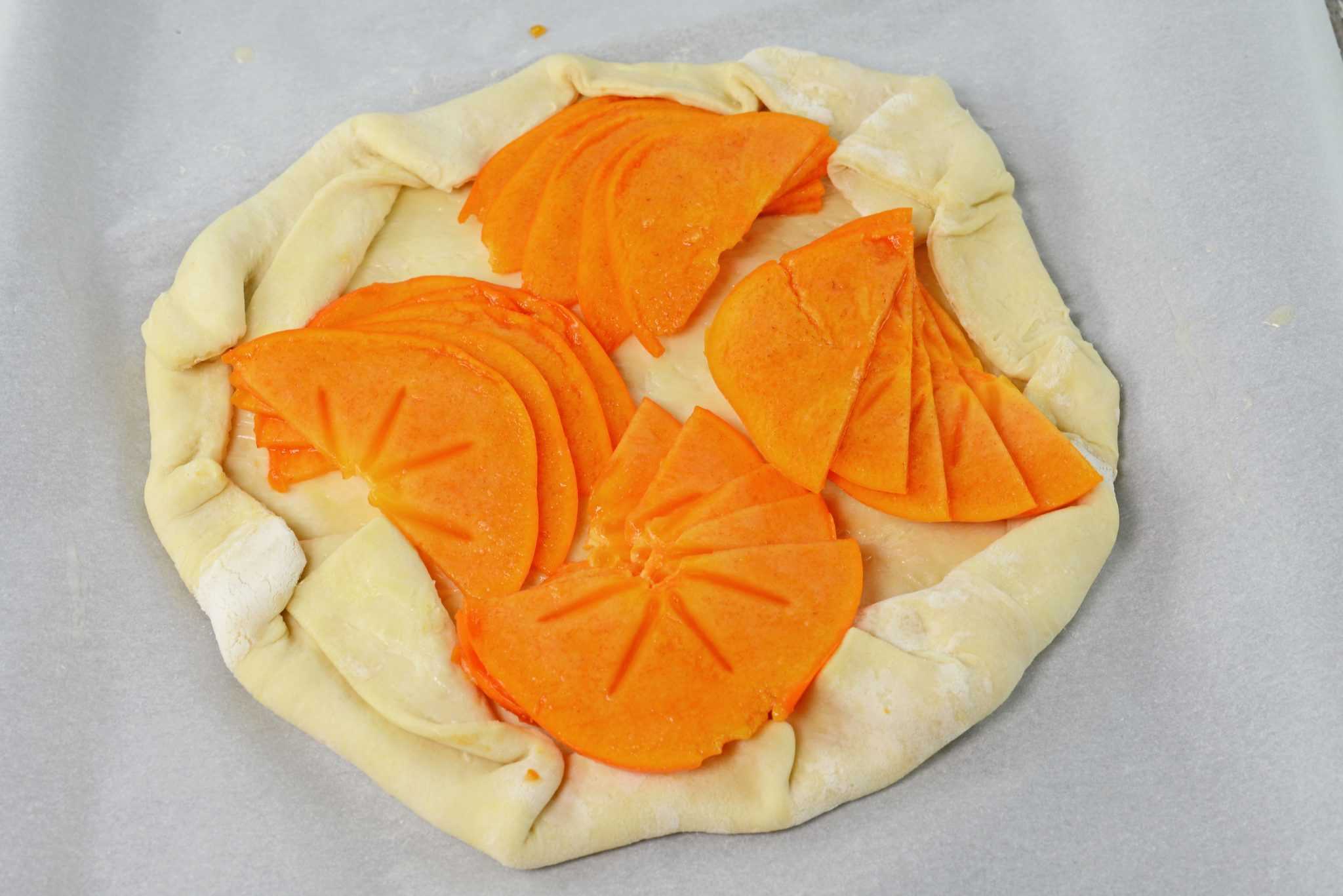 A Persimmon Tart is an easy dessert or breakfast recipe using bright orange persimmon, brown sugar and buttery puff pastry.