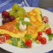 A Shrimp Omelette is a savory omelette with shrimp, scallions, spinach, tomatoes and fresh mozzarella cheese. A perfect recipe for those of us who love brunch! #shrimpomelette #omeletterecipes www.savoryexperiments.com