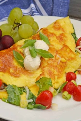 A Shrimp Omelette is a savory omelette with shrimp, scallions, spinach, tomatoes and fresh mozzarella cheese. A perfect recipe for those of us who love brunch! #shrimpomelette #omeletterecipes www.savoryexperiments.com