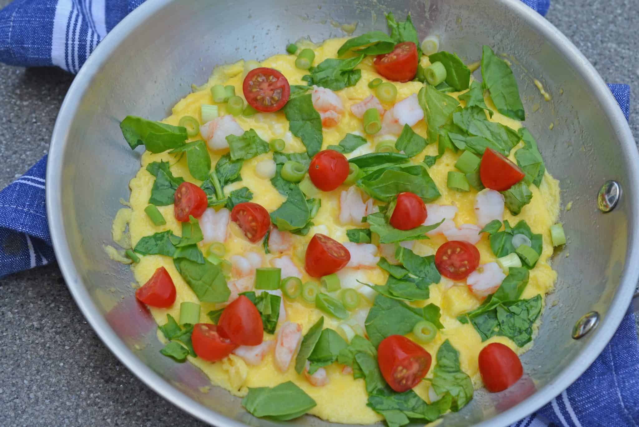Shrimp Omelette is a savory omelette using shrimp, scallions, spinach, tomatoes and fresh mozzarella cheese. The perfect recipe for brunch!