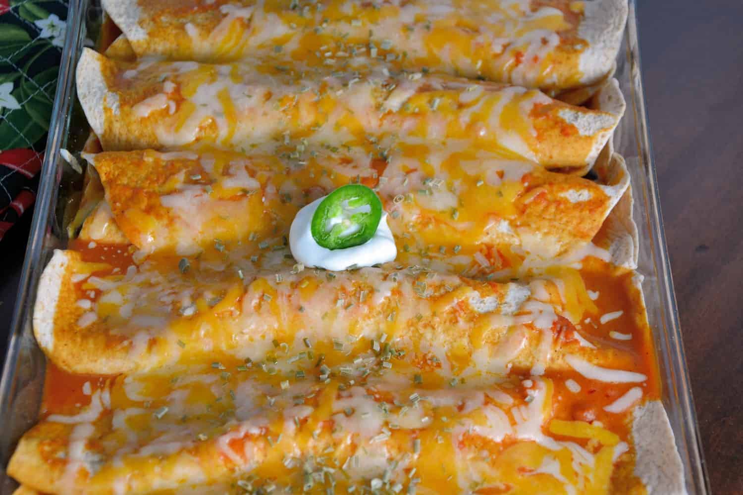 These Spinach, Black Bean and Chicken Enchiladas are rolled in flour tortillas, covered in a delicious homemade sauce and smothered in gooey cheese! Using pre-made rotisserie chicken makes them ready in a snap!