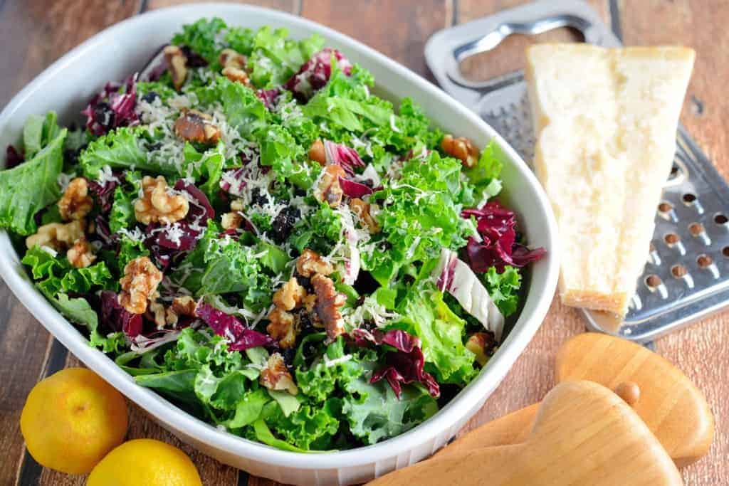 Kale Salad Recipe-tossed with currants, radicchio, walnuts and a lemon dressing. Find out my secret tips on making your kale salads silky smooth and how to make kale chips with the leftovers! www.savoryexperiments.com