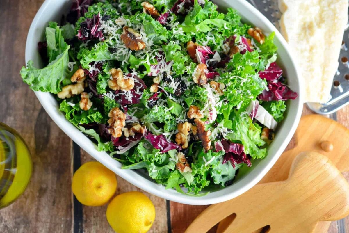 Kale Salad Recipe-tossed with currants, radicchio, walnuts and a lemon dressing. Find out my secret tips on making your kale salads silky smooth and how to make kale chips with the leftovers! www.savoryexperiments.com