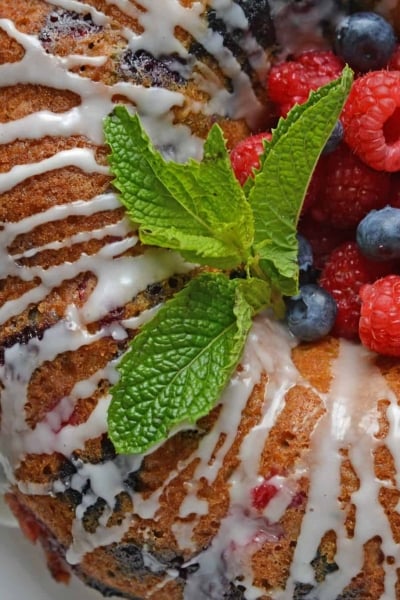 berry buttermilk bundt cake with glaze and fresh mint