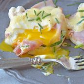 Simple Eggs Benedict tops toasted English muffins with wilted spinach, Canadian bacon, perfectly poached eggs and easy hollandaise sauce.  #eggsbenedictrecipe #easyeggsbenedict www.savoryexperiments.com