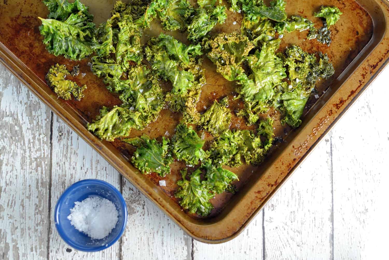 All you need for this Kale Chips recipe is kale leaves, olive oil, and sea salt! A tasty, easy, and healthy alternative to potato chips! #kalechipsrecipe #bakedkalechips www.savoryexperiments.com 