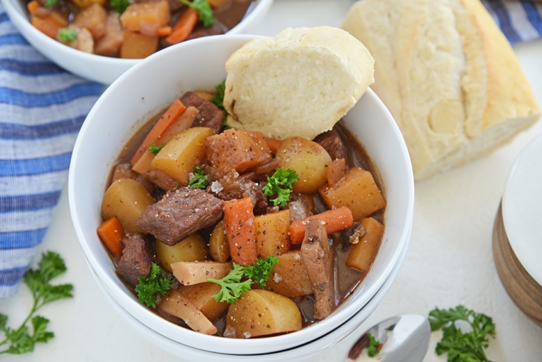 slice of bread in a bowl of red wine beef stew