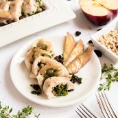 spinach stuffed chicken with apple gravy on a white plate