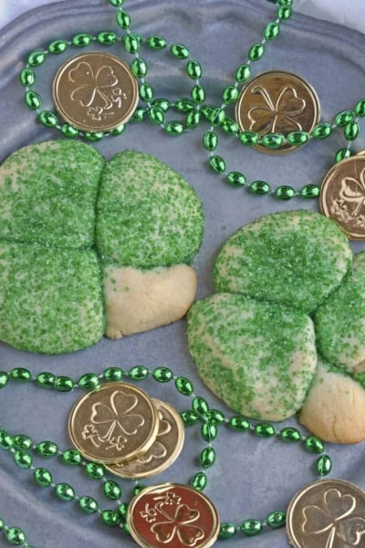 Sugar Cookie Shamrocks bring the luck of the Irish with them. St. Patrick's Day cookies creatively molded to make green lucky clovers, a great St. Patrick's Day dessert recipe. #stpatricksdayfood #stpatricksdaydessert www.savoryexperiments.com