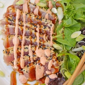 Teriyaki Ahi Tuna on a white plate with leafy greens