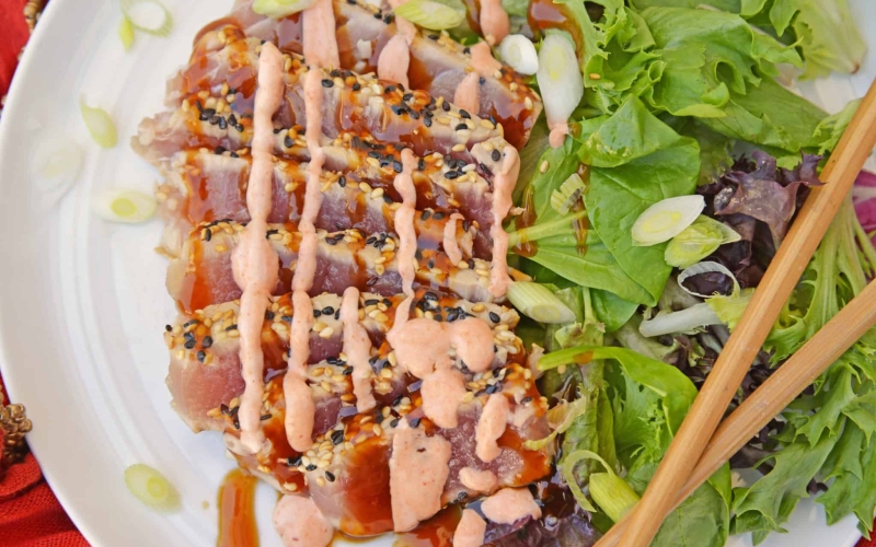 Teriyaki Ahi Tuna on a white plate with leafy greens