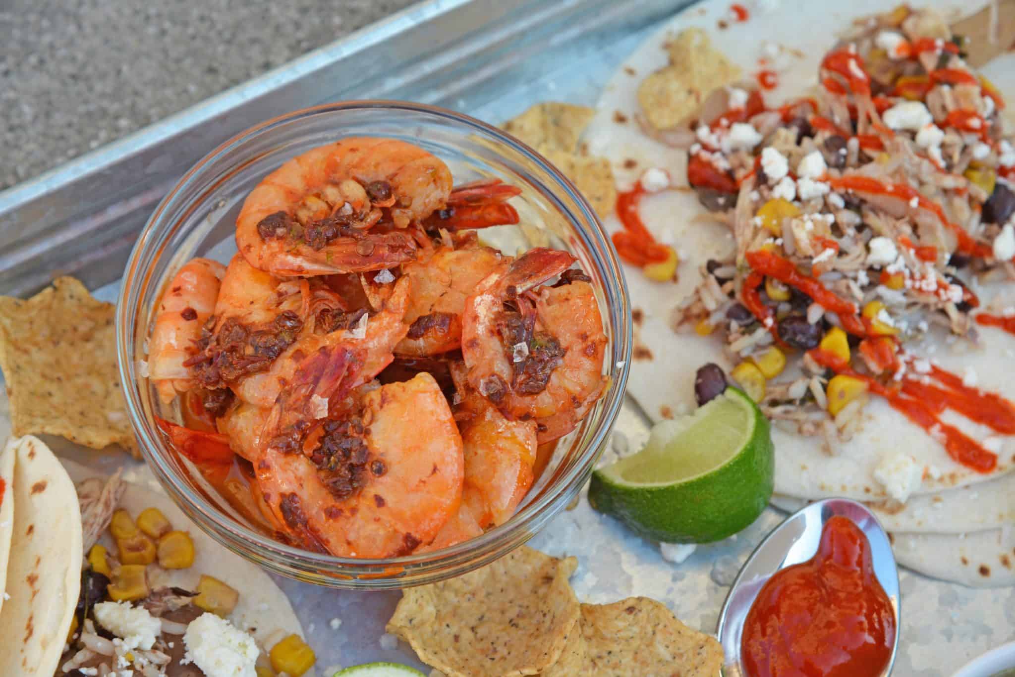 small glass bowl of chipotle shrimp on a taco tray 