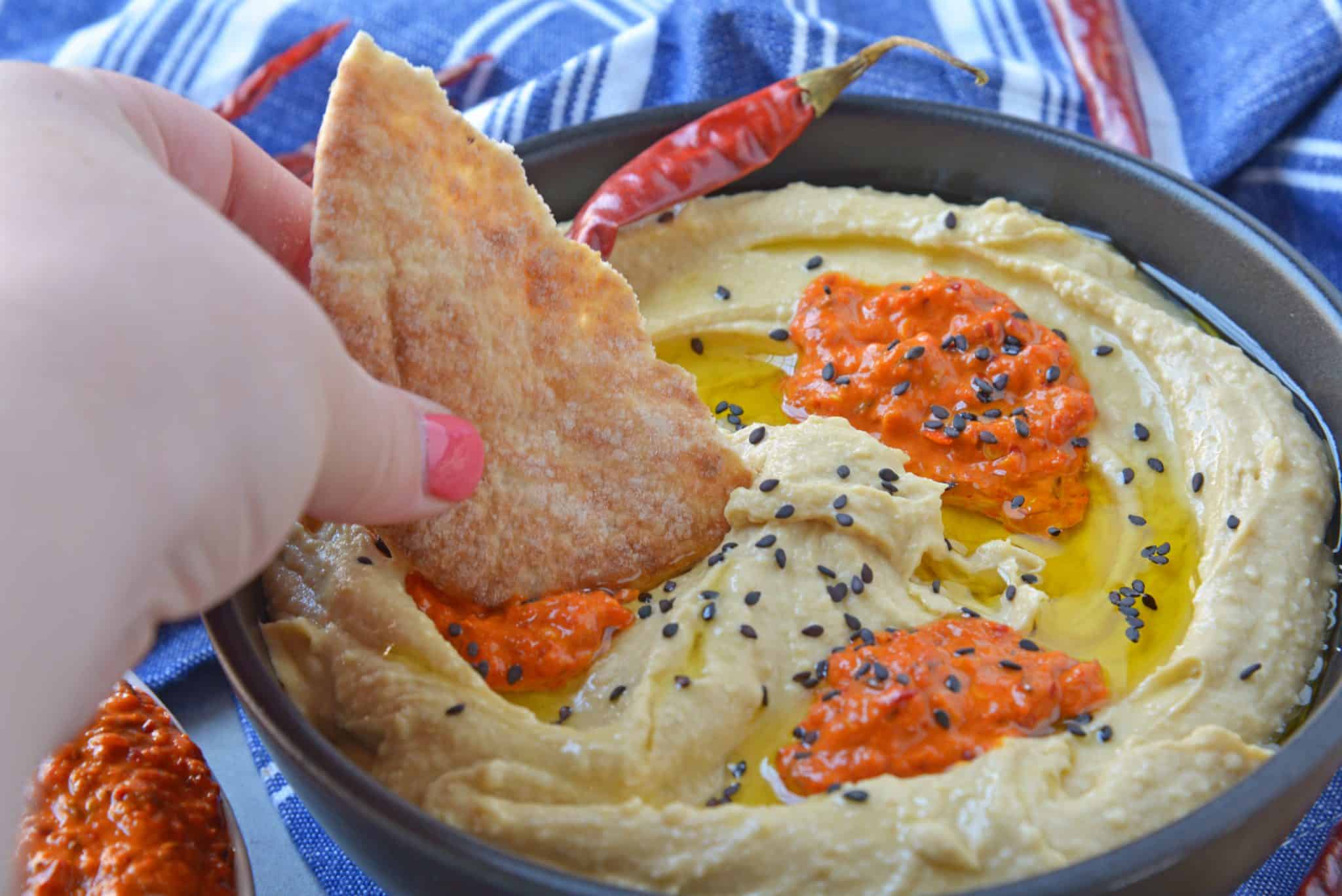 Harissa Hummus is an easy, packed full of flavor, homemade hummus recipe. Pair with vegetables or chips for a dip, or even as a spread on flatbreads or sandwiches! #spicyhummus #homemadehummusrecipe www.savoryexperiments.com