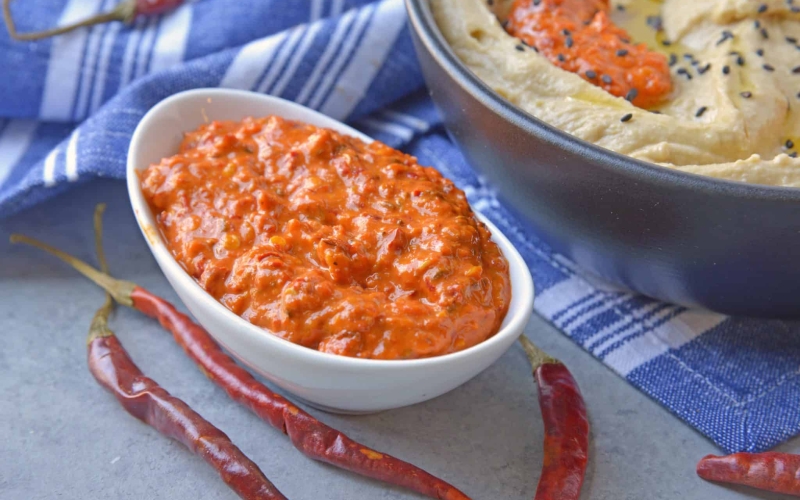 Harissa Sauce or Harissa Paste is spicy chile sauce blended with spices. Add to marinades, hummus, salad dressings and more for some heat! #harissa #hotsauce www.savoryexperiments.com