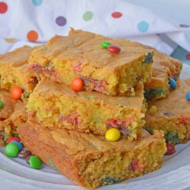 Thick and chewy M&M Cookie Bars are perfect for your cookie exchange, dessert potluck or an after school snack using just a few ingredients! #cookiebars #easydessertrecipes www.savoryexperiments.com