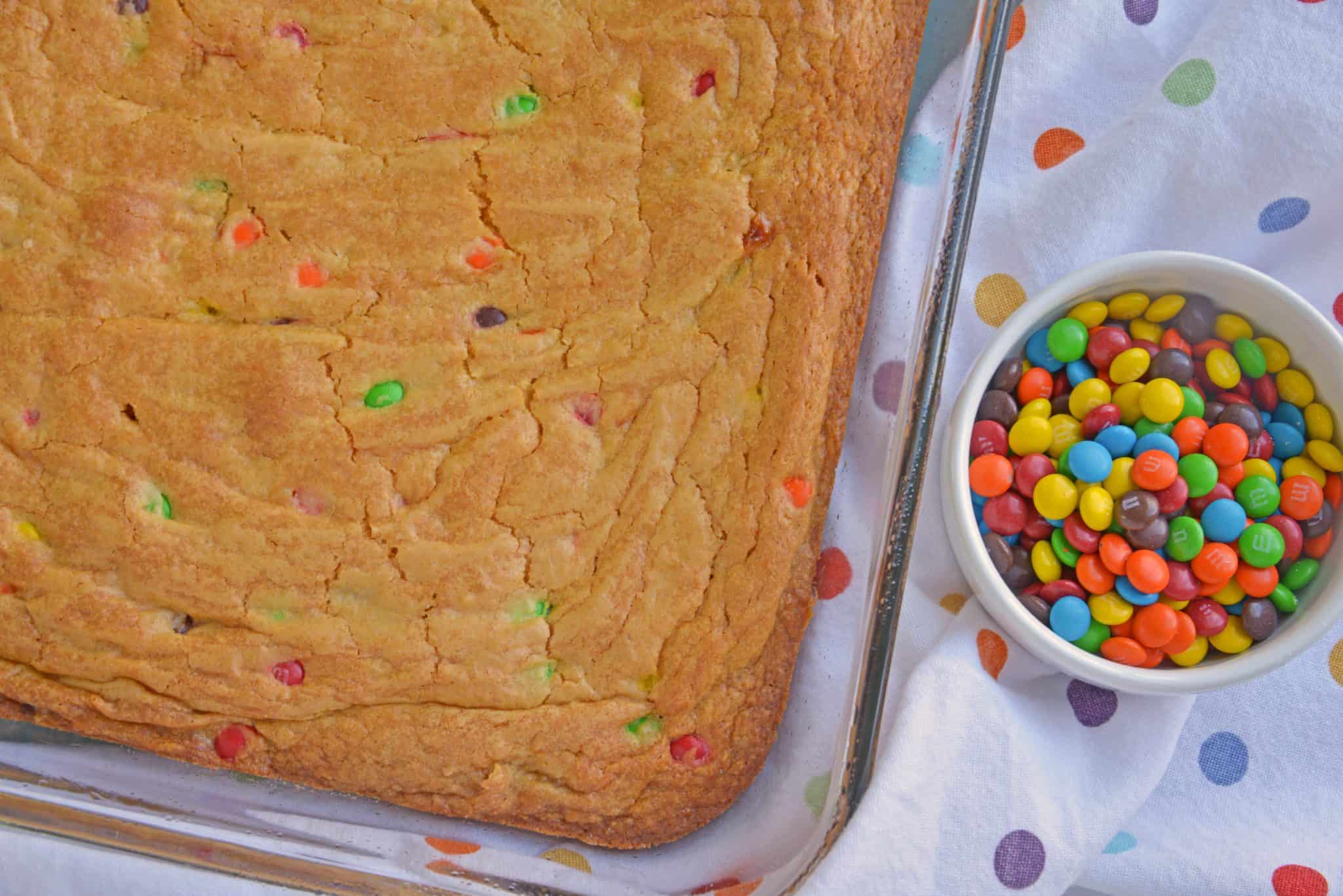 Thick and chewy M&M Cookie Bars are perfect for your cookie exchange, dessert potluck or an after school snack using just a few ingredients! #cookiebars #easydessertrecipes www.savoryexperiments.com 