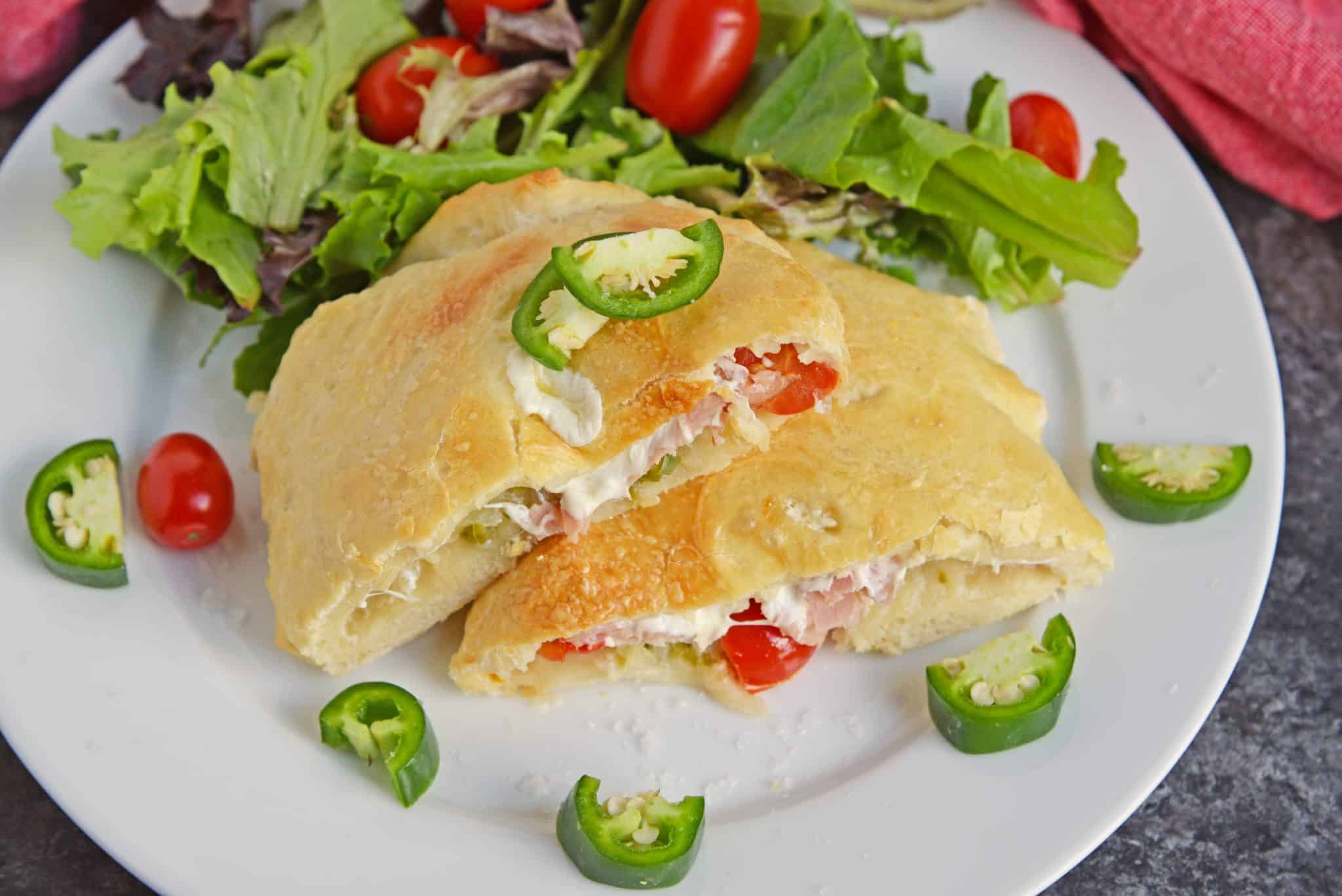 Spicy Hawaiian Calzones have become a favorite lately in this household! This is a easy calzone recipe just like your favorite Hawaiian Pizza with ham, pineapple and jalapenos! #hawaiianpizza #hawaiianfood www.savoryexperiments.com
