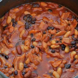 Slow Cooker Baked Beans is made with 4 types of beans simmered with brown sugar, bacon, and more! An Easy Baked Bean recipe the whole family will love. #bakedbeansrecipe #homemadebakedbeans #crockpotbakedbeans www.savoryexperiments.com