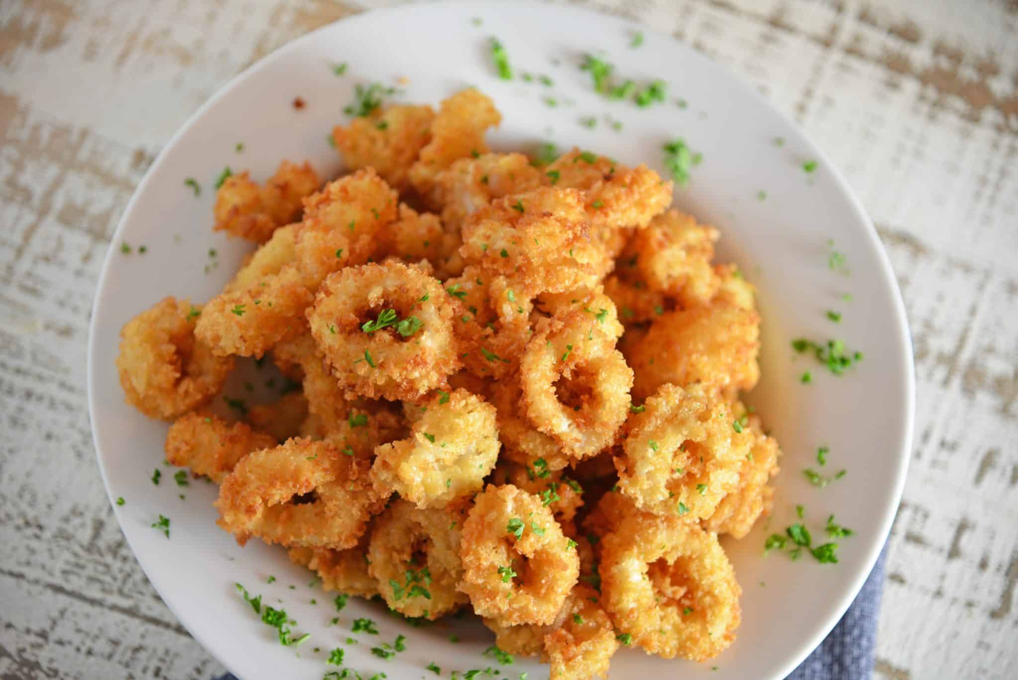 Chimichurri Fried Calamari is a quick and delicious appetizer recipe that can please any crowd! Served with fresh chimichurri sauce, it is a delicious twist. #friedcalamari #easycalamarirecipe www.savoryexperiments.com
