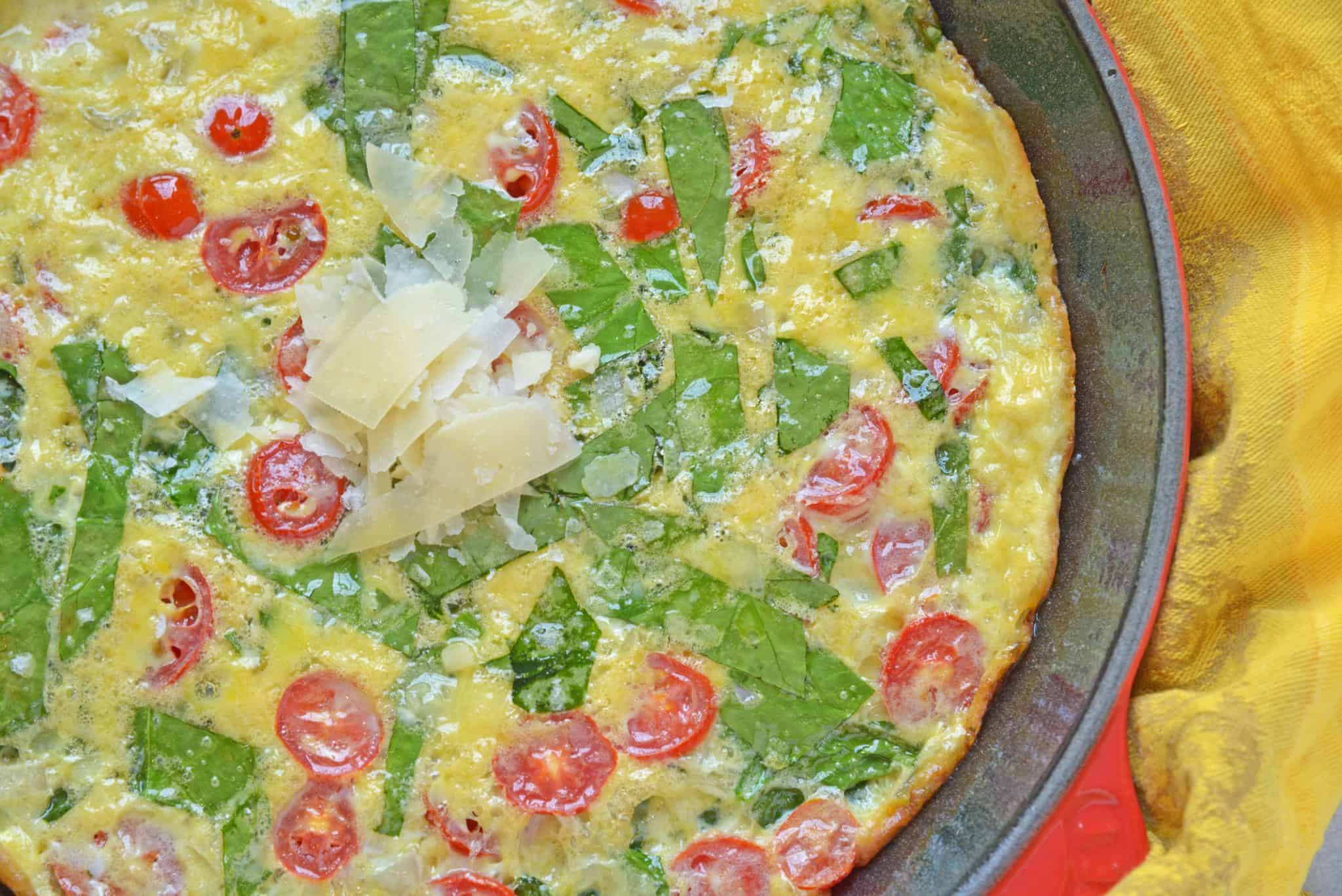 This Tomato Spinach Frittata recipe is excellent for breakfast or brunch, packed full of delicious flavors from tomatoes, spinach, shallots, and parmesan cheese! #spinachfrittata #breakfastfrittatarecipe www.savoryexperiments.com