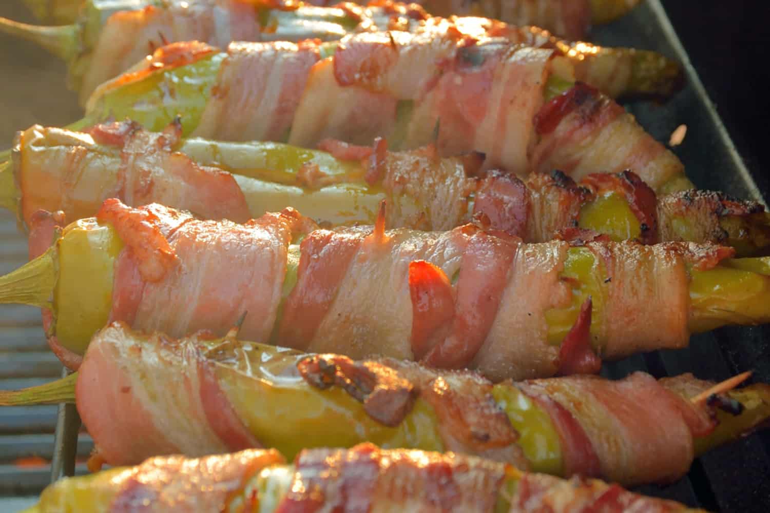Bacon Wrapped BBQ Chicken Stuffed Chile Peppers are the ultimate BBQ Chicken recipe. Tender shredded chicken stuff in a chile pepper, wrapped in bacon and drizzled with sweet agave nectar. #BBQchicken #stuffedchilepeppers www.savoryexperiments.com