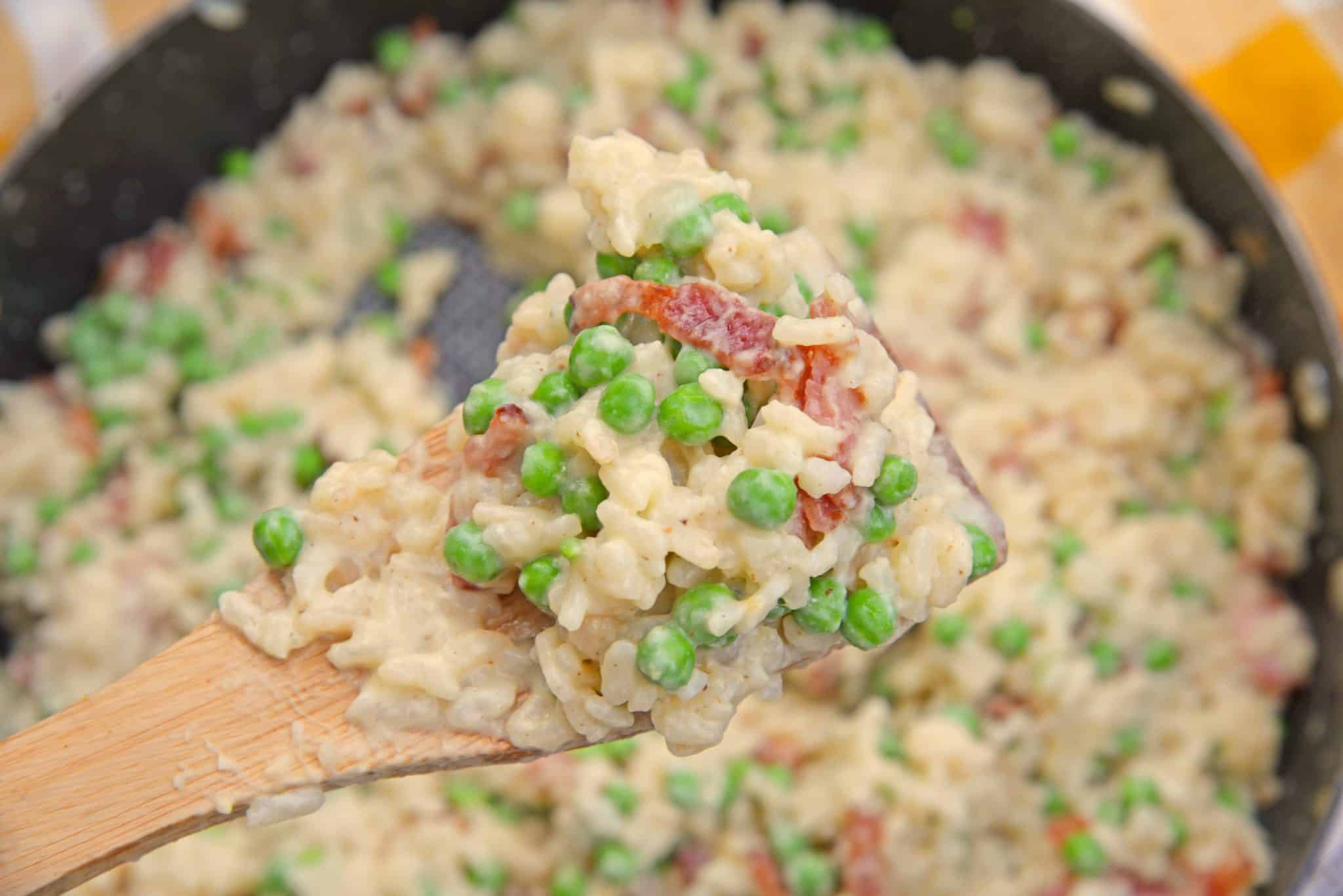 Creamy Parmesan Risotto takes the most traditional risotto recipe and adds vibrant peas and crispy bacon. Sauteed in bacon fat, this rice packs a flavor punch! #parmesanrisottorecipe #easyrisottorecipe www.savoryexperiments.com