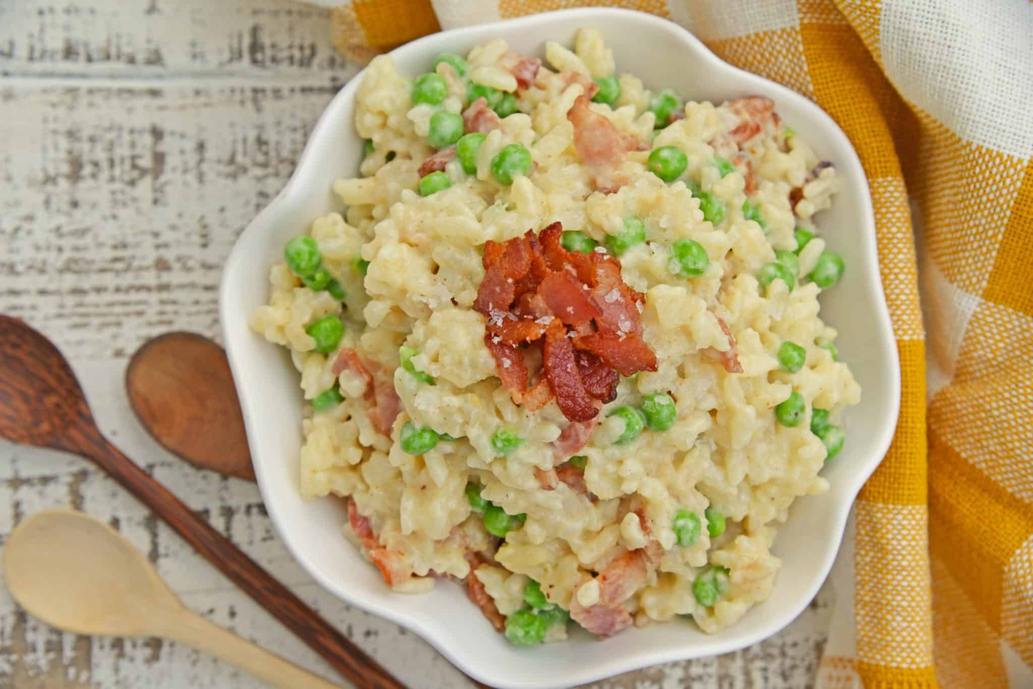 Creamy Parmesan Risotto takes the most traditional risotto recipe and adds vibrant peas and crispy bacon. Sauteed in bacon fat, this rice packs a flavor punch! #parmesanrisottorecipe #easyrisottorecipe www.savoryexperiments.com