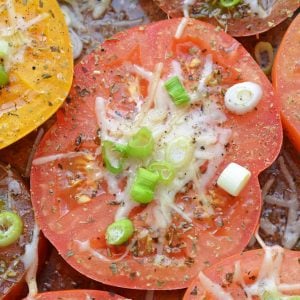 Parmesan Tomatoes are whole tomatoes, cut in half and baked with Parmesan cheese, Italian seasoning and garnished with lush scallions. An easy side dish recipe for any meal!  #tomatosidedishrecipes www.savoryexperiments.com