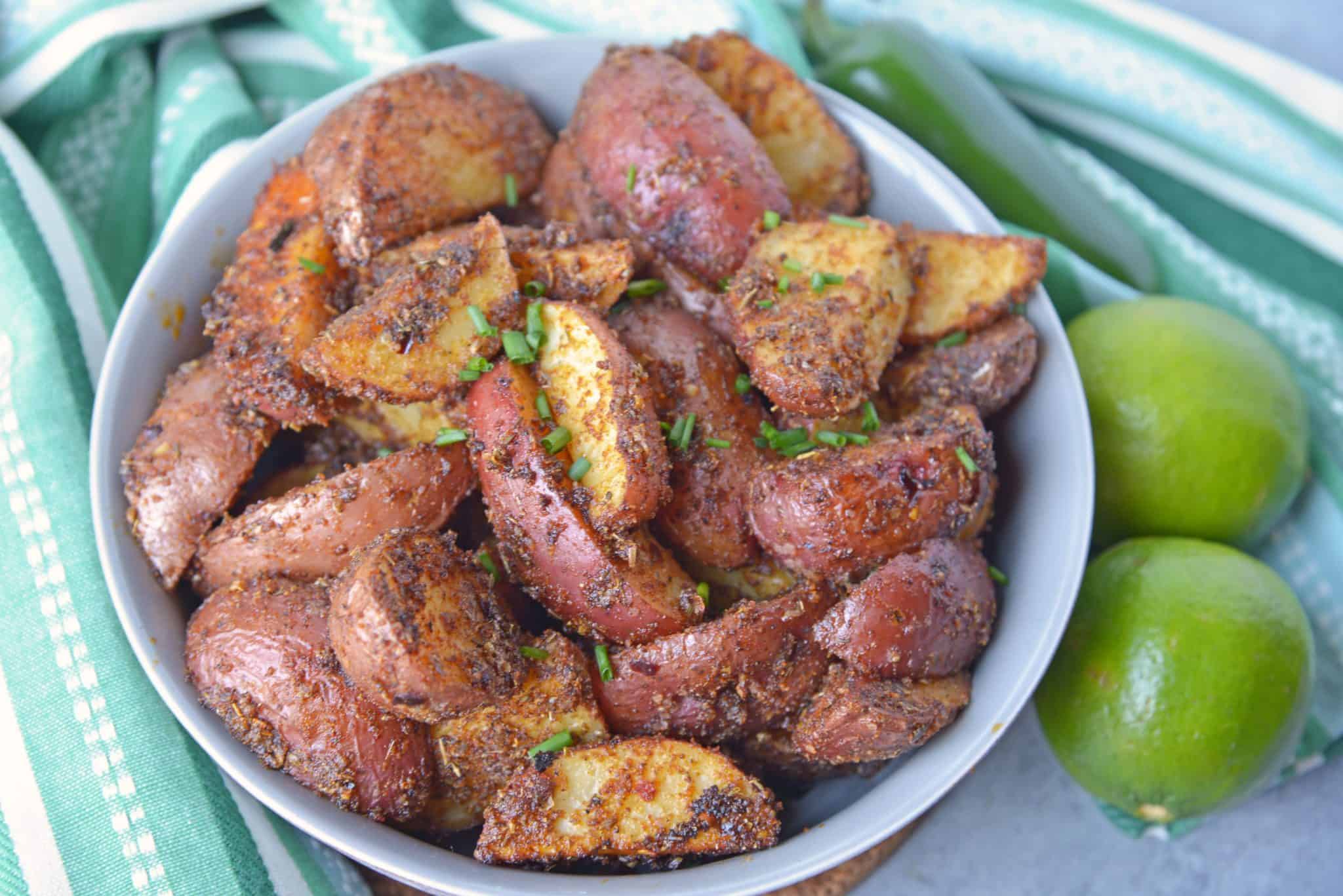 These Spicy Baked Potato Wedges are the best side dish to serve with a juicy hamburger. Tossed in a zesty spice blend, they are baked to crispy perfection.#seasonedpotatowedges #bakedpotatowedges www.savoryexperiments.com